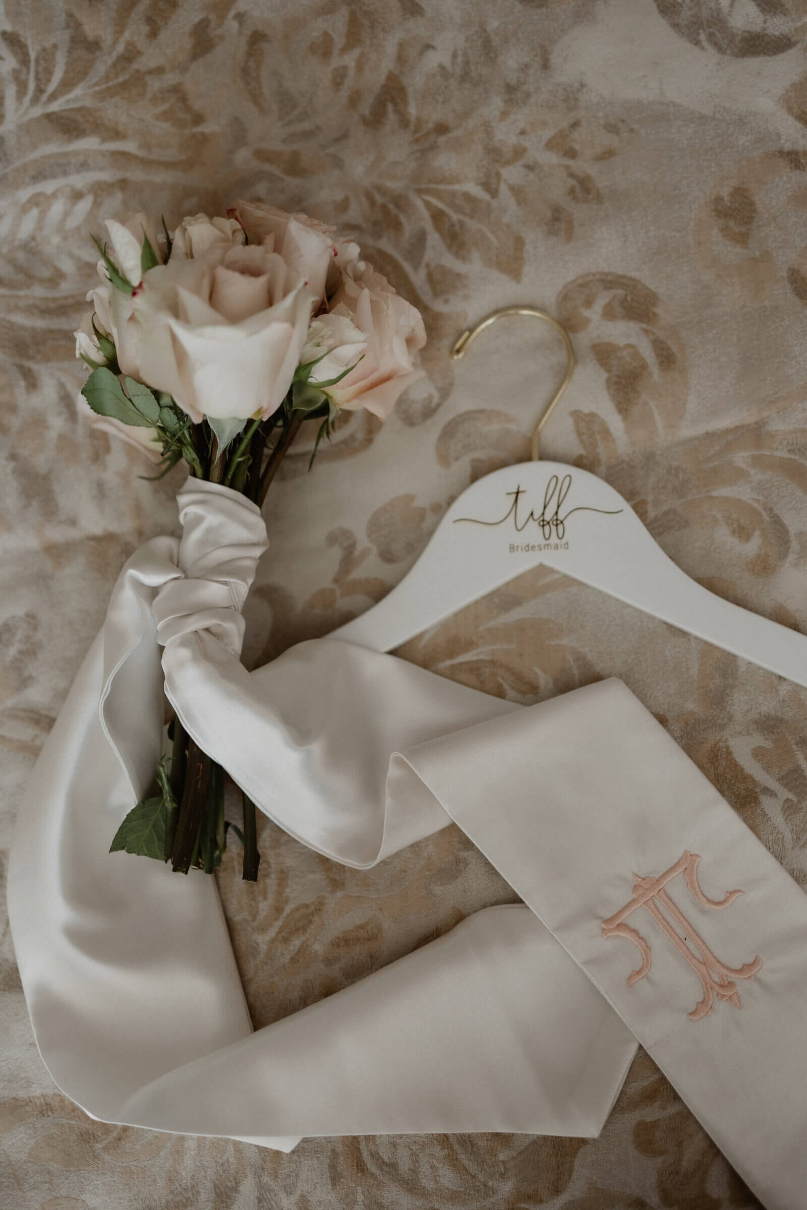 Bridesmaid bouquet and monogrammed sash flat-lay