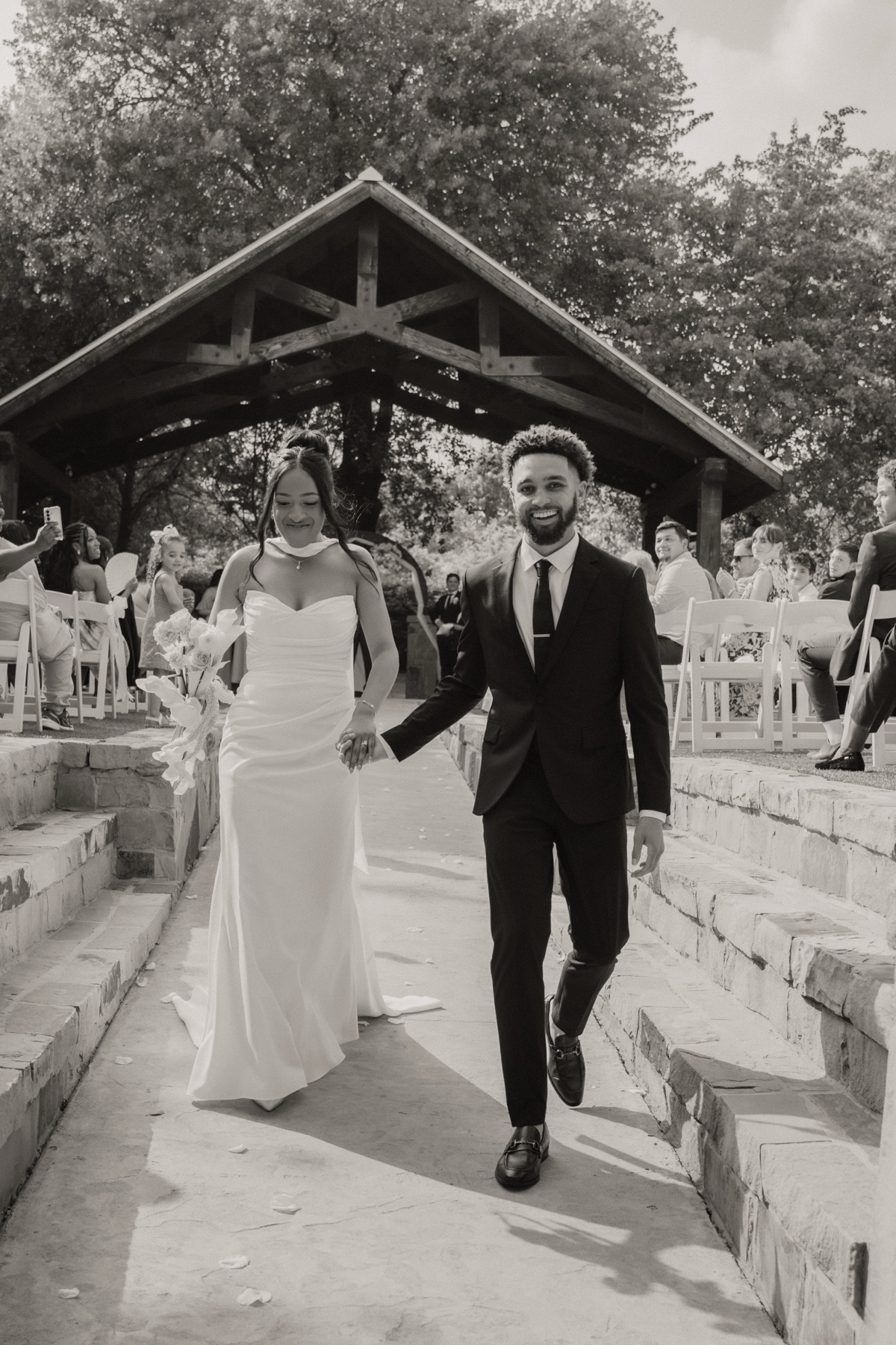Bride and groom recessional walking up the aisle in black and white